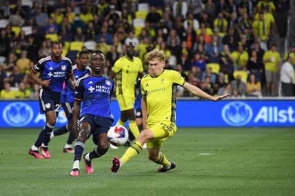 Mar 25, 2023; Nashville, Tennessee, USA; FC Cincinnati midfielder Obinna Nwobodo (5) passes the ball against Nashville SC forward Jacob Shaffelburg (14) at Geodis Park. Mandatory Credit: Christopher Hanewinckel-USA TODAY Sports