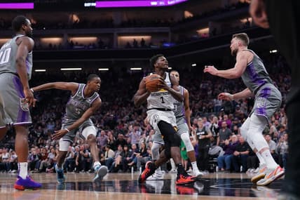 Mar 27, 2023; Sacramento, California, USA; Minnesota Timberwolves guard Anthony Edwards (1) drives to the hoop between Sacramento Kings guard De'Aaron Fox (5) and forward Domantas Sabonis (10) in the second quarter at the Golden 1 Center. Mandatory Credit: Cary Edmondson-USA TODAY Sports