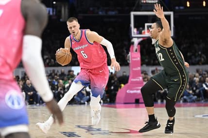Mar 28, 2023; Washington, District of Columbia, USA; Washington Wizards center Kristaps Porzingis (6) dribbles past Boston Celtics forward Grant Williams (12) during the second half at Capital One Arena. Mandatory Credit: Brad Mills-USA TODAY Sports