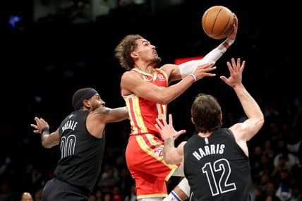Mar 31, 2023; Brooklyn, New York, USA; Atlanta Hawks guard Trae Young (11) drives to the basket against Brooklyn Nets forwards Royce O'Neale (00) and Joe Harris (12) during the second quarter at Barclays Center. Mandatory Credit: Brad Penner-USA TODAY Sports