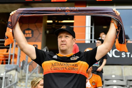 Apr 16, 2022; Houston, Texas, USA;  A fan holds up a scarf in support of the Houston Dynamo FC prior to the match against the Portland Timbers at PNC Stadium. Mandatory Credit: Maria Lysaker-Houston Dynamo-USA TODAY Sports
