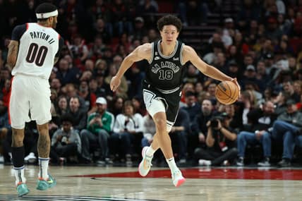 Jan 23, 2023; Portland, Oregon, USA; San Antonio Spurs forward Isaiah Roby (18) dribbles past Portland Trail Blazers guard Gary Payton II (00) in the second half at Moda Center. Mandatory Credit: Jaime Valdez-USA TODAY Sports