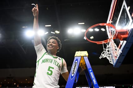 Mar 30, 2023; Las Vegas, NV, USA;  North Texas Mean Green guard Tylor Perry (5) cuts the net after defeating the UAB Blazers to win the NIT Championship at Orleans Arena. Mandatory Credit: Candice Ward-USA TODAY Sports