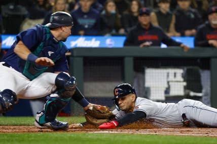 Mar 31, 2023; Seattle, Washington, USA; Cleveland Guardians second baseman Andres Gimenez (0) eludes a tag by Seattle Mariners catcher Cal Raleigh (29) following a second throwing error during the second inning at T-Mobile Park. Mandatory Credit: Joe Nicholson-USA TODAY Sports