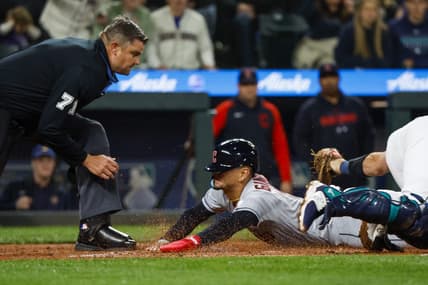 Mar 31, 2023; Seattle, Washington, USA; Cleveland Guardians second baseman Andres Gimenez (0) eludes a tag by Seattle Mariners catcher Cal Raleigh (29) following a second throwing error during the second inning at T-Mobile Park. Home plate umpire Jordan Baker (71) watches before making the call. Mandatory Credit: Joe Nicholson-USA TODAY Sports