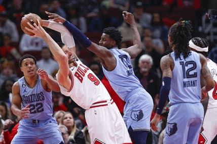 Apr 2, 2023; Chicago, Illinois, USA; Memphis Grizzlies forward Jaren Jackson Jr. (13) fouls Chicago Bulls center Nikola Vucevic (9) during the first half at United Center. Mandatory Credit: Kamil Krzaczynski-USA TODAY Sports