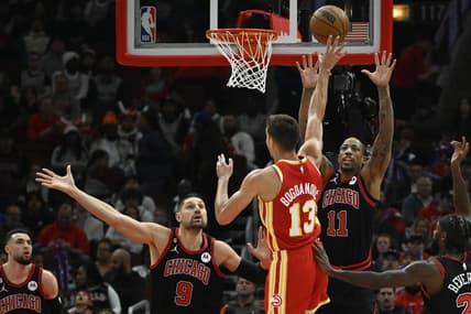 Apr 4, 2023; Chicago, Illinois, USA;  Atlanta Hawks guard Bogdan Bogdanovic (13) shoots against Chicago Bulls center Nikola Vucevic (9) and forward DeMar DeRozan (11) during the first half at the  United Center. Mandatory Credit: Matt Marton-USA TODAY Sports
