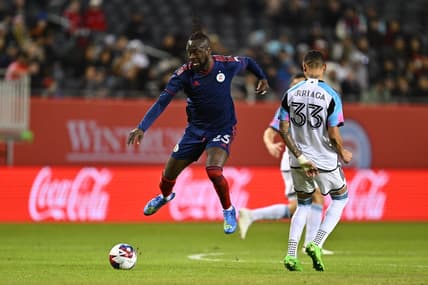Apr 8, 2023; Chicago, Illinois, USA;  Chicago Fire FC forward Kei Kamara (23) leaps past Minnesota United midfielder Kervin Arriaga (33) to gain control of the ball in the first half at Soldier Field. Mandatory Credit: Jamie Sabau-USA TODAY Sports