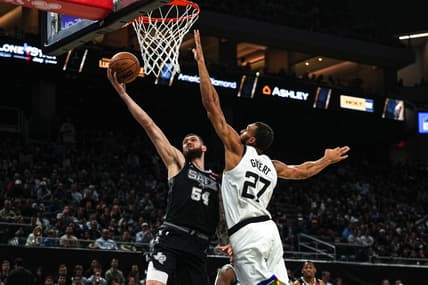 April 8, 2023; Austin, TX, USA; San Antonio Spurs forward Sandro Mamukelashvili (54) shoots past Minnesota Timberwolves center Rudy Gobert (27) during the game at the Moody Center on Saturday, April 8, 2023 in Austin. Mandatory Credit: Aaron E. Martinez-USA TODAY NETWORK