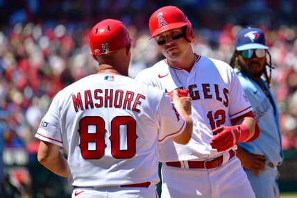 Apr 9, 2023; Anaheim, California, USA; Los Angeles Angels right fielder Hunter Renfroe (12) is greeted by first base coach Damon Mashore (80) after hitting a single against the Toronto Blue Jays during the third inning at Angel Stadium. Mandatory Credit: Gary A. Vasquez-USA TODAY Sports