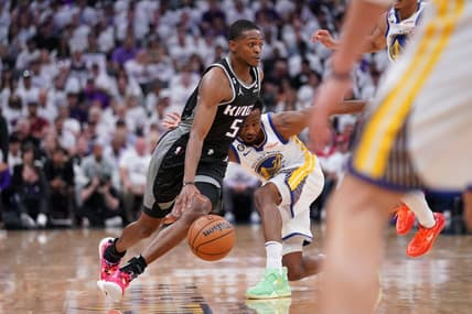 Apr 15, 2023; Sacramento, California, USA; Sacramento Kings guard De'Aaron Fox (5) dribbles past Golden State Warriors forward Andrew Wiggins (22) in the first quarter during game one of the 2023 NBA playoffs at the Golden 1 Center. Mandatory Credit: Cary Edmondson-USA TODAY Sports