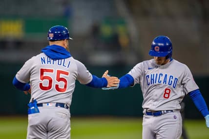 Apr 17, 2023; Oakland, California, USA;  Chicago Cubs left fielder Ian Happ (8) and Chicago Cubs first base coach Mike Napoli (55) celebrate at first base against the Oakland Athletics during the fourth inning at RingCentral Coliseum. Mandatory Credit: Neville E. Guard-USA TODAY Sports