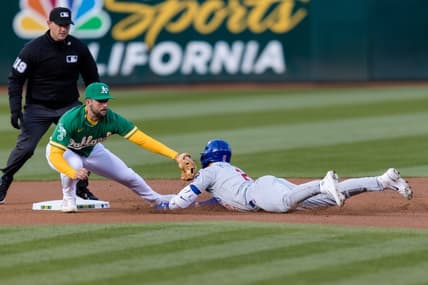 Apr 18, 2023; Oakland, California, USA;  Chicago Cubs second baseman Nico Hoerner (2) dives into second for a double against Oakland Athletics shortstop Kevin Smith (4) during the first inning at RingCentral Coliseum. Mandatory Credit: John Hefti-USA TODAY Sports