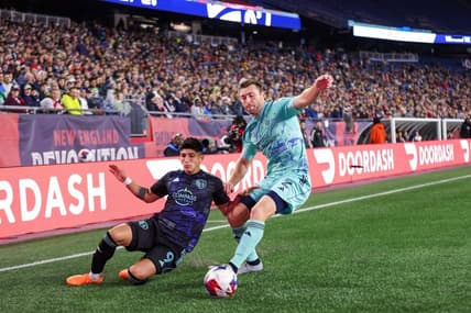 Apr 22, 2023; Foxborough, Massachusetts, USA; New England Revolution defender Dave Romney (2) defends Sporting Kansas City forward Alan Pulido (9) during the first half at Gillette Stadium. Mandatory Credit: Paul Rutherford-USA TODAY Sports