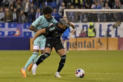 Apr 22, 2023; Montreal, Quebec, CAN; CF Montreal forward Ariel Lassiter (11) kicks the ball past New York Red Bulls defender Kyle Duncan (6) during the first half at Stade Saputo. Mandatory Credit: Eric Bolte-USA TODAY Sports