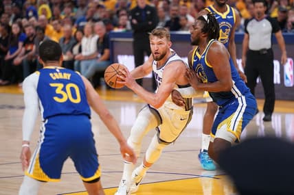 Apr 28, 2023; San Francisco, California, USA; Sacramento Kings forward Domantas Sabonis (10) holds onto the ball next to Golden State Warriors forward Kevon Looney (5) in the first quarter during game six of the 2023 NBA playoffs at the Chase Center. Mandatory Credit: Cary Edmondson-USA TODAY Sports