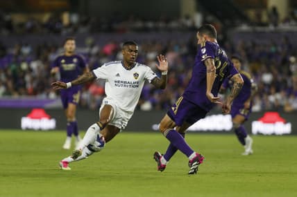 Apr 29, 2023; Orlando, Florida, USA; Orlando City SC defender Kyle Smith (24) passes the ball through the legs of Los Angeles Galaxy midfielder Douglas Costa (10) in the first half at Exploria Stadium. Mandatory Credit: Morgan Tencza-USA TODAY Sports