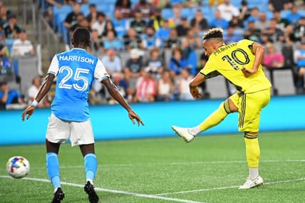 Jul 9, 2022; Charlotte, North Carolina, USA; Nashville SC midfielder Hany Mukhtar (10) with his arm behind his back after he shoots as Charlotte FC defender Harrison Afful (25) defends in the second half at Bank of America Stadium. Mandatory Credit: Bob Donnan-USA TODAY Sports