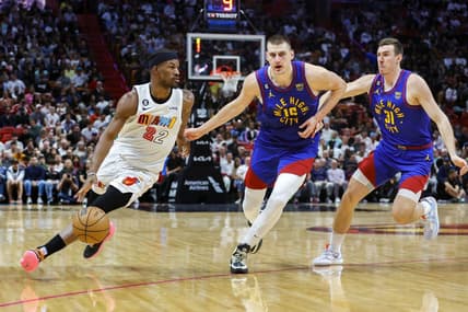 Feb 13, 2023; Miami, Florida, USA; Miami Heat forward Jimmy Butler (22) dribbles the basketball ahead of Denver Nuggets center Nikola Jokic (15) and forward Vlatko Cancar (31) during the second quarter at Miami-Dade Arena. Mandatory Credit: Sam Navarro-USA TODAY Sports