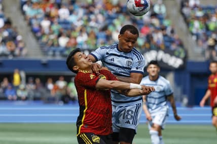 May 7, 2023; Seattle, Washington, USA; Sporting Kansas City defender Logan Ndenbe (18) fouls Seattle Sounders FC forward Fredy Montero (12) during the second half at Lumen Field. Seattle was awarded a penalty kick on the play; the kick was converted for a goal. Mandatory Credit: Joe Nicholson-USA TODAY Sports