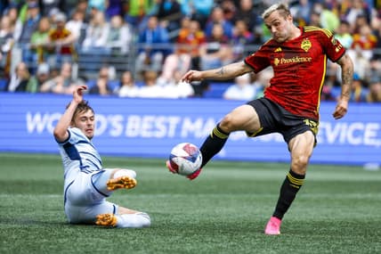 May 7, 2023; Seattle, Washington, USA; Seattle Sounders FC forward Jordan Morris (13, right) attempts a shot against Sporting Kansas City midfielder Jake Davis (17) during the second half at Lumen Field. Mandatory Credit: Joe Nicholson-USA TODAY Sports