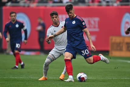 May 13, 2023; Chicago, Illinois, USA;  Chicago Fire FC midfielder Gaston Gimenez (30) controls the ball as St. Louis City SC midfielder Celio Pompeu (12) defends in the first half at Soldier Field. Mandatory Credit: Jamie Sabau-USA TODAY Sports