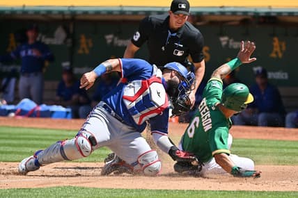 May 13, 2023; Oakland, California, USA; Texas Rangers catcher Sandy Leon (12) tags out Oakland Athletics infielder Jace Peterson (6) during the seventh inning at Oakland-Alameda County Coliseum. Mandatory Credit: Robert Edwards-USA TODAY Sports