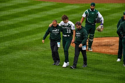 May 13, 2023; Denver, Colorado, USA; Colorado Rockies starting pitcher Ryan Feltner (18) is helped off the field by the medical staff after getting hit by a line drive by Philadelphia Phillies Nick Castellanos in the second inning at Coors Field. Mandatory Credit: John Leyba-USA TODAY Sports