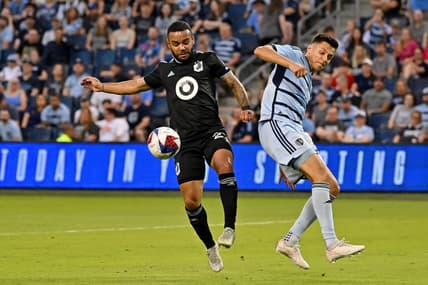 May 13, 2023; Kansas City, Kansas, USA; Minnesota United defender D.J. Taylor (27) battles for the ball against Sporting Kansas City forward Daniel Salloi (20) at Children's Mercy Park. Mandatory Credit: Peter Aiken-USA TODAY Sports