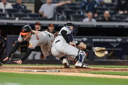 May 24, 2023; Bronx, New York, USA; Baltimore Orioles third baseman Gunnar Henderson (2) dives past New York Yankees catcher Kyle Higashioka (66) to score a run during the seventh inning at Yankee Stadium. Mandatory Credit: Vincent Carchietta-USA TODAY Sports
