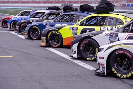 May 27, 2023; Concord, North Carolina, USA; Cars lined up in the starting grid with bagged car covers on the roofs in hopes of the rain not delaying the start during the Alsco Uniforms 300 at Charlotte Motor Speedway. Mandatory Credit: Jim Dedmon-USA TODAY Sports