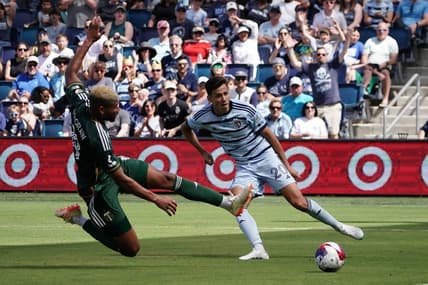 May 28, 2023; Kansas City, Kansas, USA; Sporting Kansas City forward Daniel Salloi (20) shoots the ball against Portland Timbers defender Zac McGraw (18) during the second half at Children's Mercy Park. Mandatory Credit: Denny Medley-USA TODAY Sports