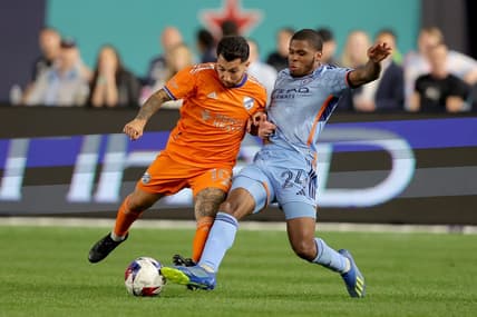 May 31, 2023; New York, New York, USA; FC Cincinnati midfielder Luciano Acosta (10) and New York City FC defender Tayvon Gray (24) fight for the ball during the second half at Yankee Stadium. Mandatory Credit: Brad Penner-USA TODAY Sports