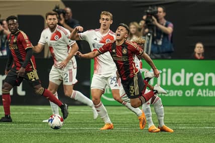 May 31, 2023; Atlanta, Georgia, USA; Atlanta United midfielder Thiago Almada (23) trips over New England Revolution forward Latif Blessing (19) during the first half at Mercedes-Benz Stadium. Mandatory Credit: Dale Zanine-USA TODAY Sports