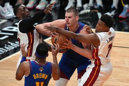 Jun 7, 2023; Miami, Florida, USA; Denver Nuggets center Nikola Jokic (15) grabs a rebound over Miami Heat guard Kyle Lowry (7) and center Bam Adebayo (13) during the second quarter in game three of the 2023 NBA Finals at Kaseya Center. Mandatory Credit: Jim Rassol-USA TODAY Sports