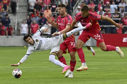 Jun 11, 2023; St. Louis, Missouri, USA; Los Angeles Galaxy midfielder Riqui Puig (6) and St. Louis City midfielder Eduard Lowen (10) and defender Lucas Bartlett (24) collide in the first half at CITYPARK. Mandatory Credit: Scott Rovak-USA TODAY Sports