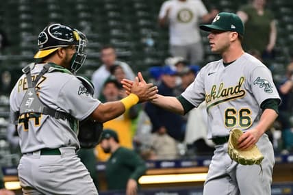 Jun 11, 2023; Milwaukee, Wisconsin, USA; Oakland Athletes pitcher Sam Long (66) celebrates with catcher Carlos P  rez (44) after picking up a save against the Milwaukee Brewers at American Family Field. Mandatory Credit: Benny Sieu-USA TODAY Sports