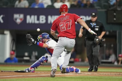 Jun 14, 2023; Arlington, Texas, USA; Los Angeles Angels center fielder Mike Trout (27) runs home to score as Texas Rangers catcher Mitch Garver (18) is unable to catch the throw during the third inning at Globe Life Field. Mandatory Credit: Jim Cowsert-USA TODAY Sports