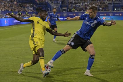 Jun 21, 2023; Montreal, Quebec, CAN;  Nashville SC defender Shaq Moore (18) battles for the ball against CF Montreal defender Gabriele Corbo (25) in the second half at Stade Saputo. Mandatory Credit: Eric Bolte-USA TODAY Sports