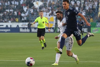 Jun 21, 2023; Carson, California, USA; Sporting Kansas City forward Daniel Salloi (20) fights for the ball against LA Galaxy midfielder Gaston Brugman (5) during the first half of the MLS game at Dignity Health Sports Park. Mandatory Credit: Kiyoshi Mio-USA TODAY Sports