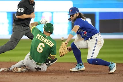 Jun 24, 2023; Toronto, Ontario, CAN; Oakland Athletics third baseman Jace Peterson (6) slides safely into second base on a double as Toronto Blue Jays shortstop Bo Bichette (11) misses the catch in during the second inning at Rogers Centre. Mandatory Credit: John E. Sokolowski-USA TODAY Sports