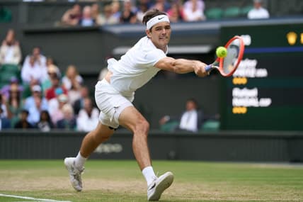 Jul 6, 2022; London, England, United Kingdom; Taylor Fritz (USA) returns a shot during his quarter finals men   s singles match against Rafael Nadal (ESP) on Centre court at All England Lawn Tennis and Croquet Club. Mandatory Credit: Peter van den Berg-USA TODAY Sports