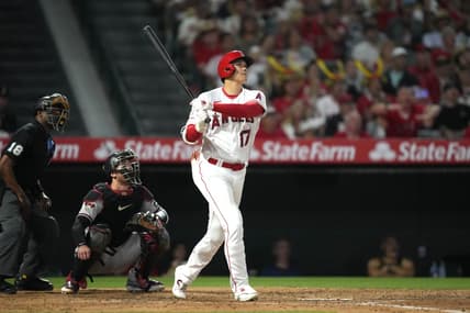 Jun 30, 2023; Anaheim, California, USA; Los Angeles Angels starting pitcher Shohei Ohtani (17) follows through on a solo home run in the sixth inning as Arizona Diamondbacks catcher Carson Kelly (18) and home plate umpire Ramon De Jesus watch at Angel Stadium. Mandatory Credit: Kirby Lee-USA TODAY Sports