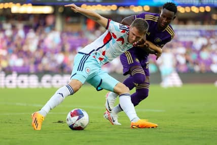 Jul 1, 2023; Orlando, Florida, USA;  Chicago Fire FC defender Arnaud Souquet (2) and Orlando City SC forward Ivan Angulo (77)  battle for the ball in the first half at Exploria Stadium. Mandatory Credit: Nathan Ray Seebeck-USA TODAY Sports