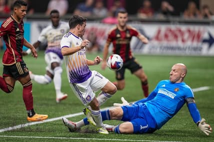 Jul 15, 2023; Atlanta, Georgia, USA; Atlanta United goalkeeper Brad Guzan (1) stops a scoring chance by Orlando City midfielder Mauricio Pereyra (10) during the first half at Mercedes-Benz Stadium. Mandatory Credit: Dale Zanine-USA TODAY Sports