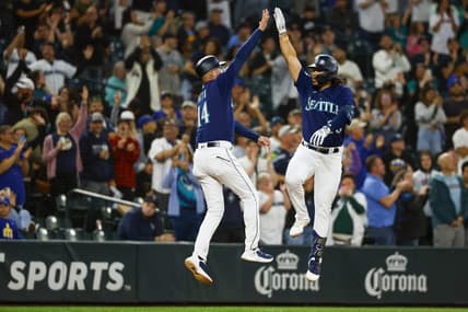 Jul 17, 2023; Seattle, Washington, USA; Seattle Mariners third baseman Eugenio Suarez (28) makes a jumping high-five with third base coach Manny Acta (14) while running the bases after hitting a two-run home run against the Minnesota Twins during the seventh inning at T-Mobile Park. Mandatory Credit: Joe Nicholson-USA TODAY Sports