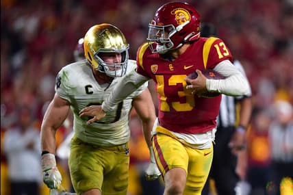 Nov 26, 2022; Los Angeles, California, USA; Southern California Trojans quarterback Caleb Williams (13) runs the ball ahead of Notre Dame Fighting Irish linebacker JD Bertrand (27)  during the second half at the Los Angeles Memorial Coliseum. Mandatory Credit: Gary A. Vasquez-USA TODAY Sports