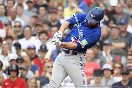Aug 5, 2023; Boston, Massachusetts, USA;  Toronto Blue Jays designated hitter Brandon Belt (13) hits an RBI single during the sixth inning against the Boston Red Sox at Fenway Park. Mandatory Credit: Bob DeChiara-USA TODAY Sports