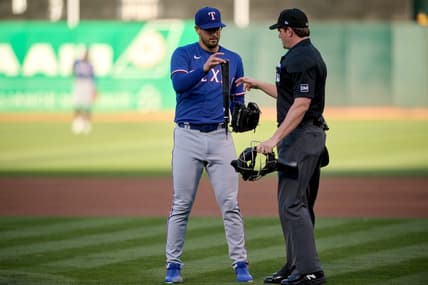 Aug 7, 2023; Oakland, California, USA; Texas Rangers starting pitcher Dane Dunning (33) hands a piece of a broken bat to home plate umpire Adam Beck (38) during the first inning at Oakland-Alameda County Coliseum. Mandatory Credit: Robert Edwards-USA TODAY Sports