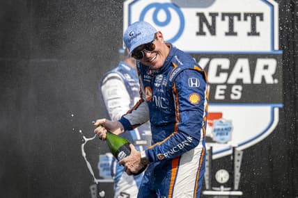 Aug 12, 2023; Speedway, Indiana, USA; Chip Ganassi Racing driver Scott Dixon (9) turns away from Rahal Letterman Lanigan Racing driver Graham Rahal (15) during the champagne fight on the podium after the Gallagher Grand Prix at the Indianapolis Motor Speedway Road Course. Mandatory Credit: Marc Lebryk-USA TODAY Sports